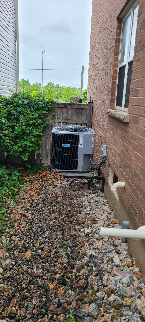Completed outdoor air conditioner installation in a gravel side yard