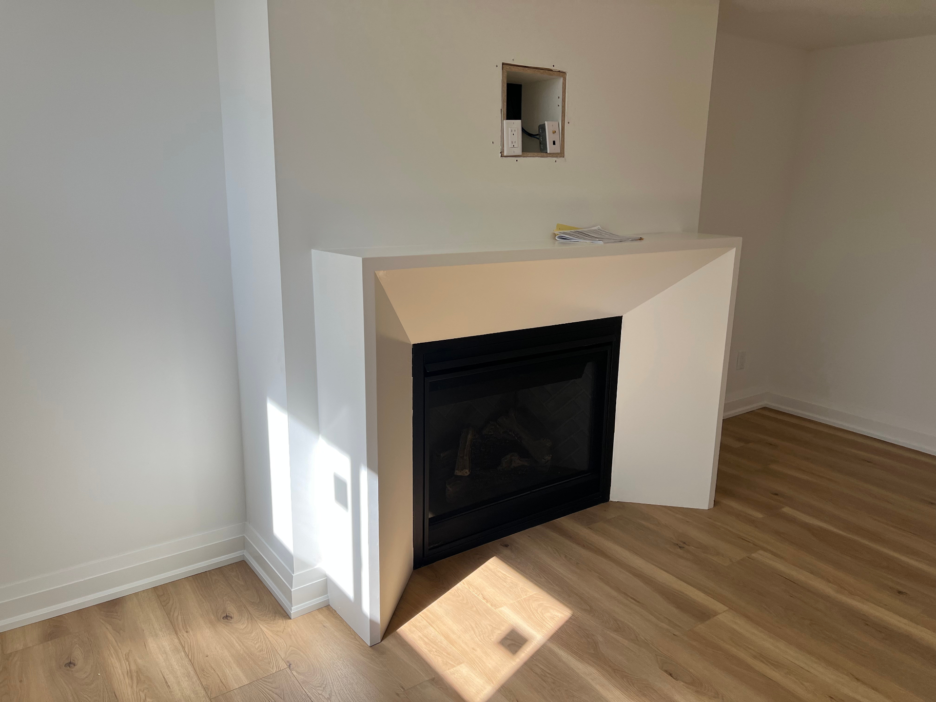 Basement renovation with modern gas fireplace and drywall surround in Niagara