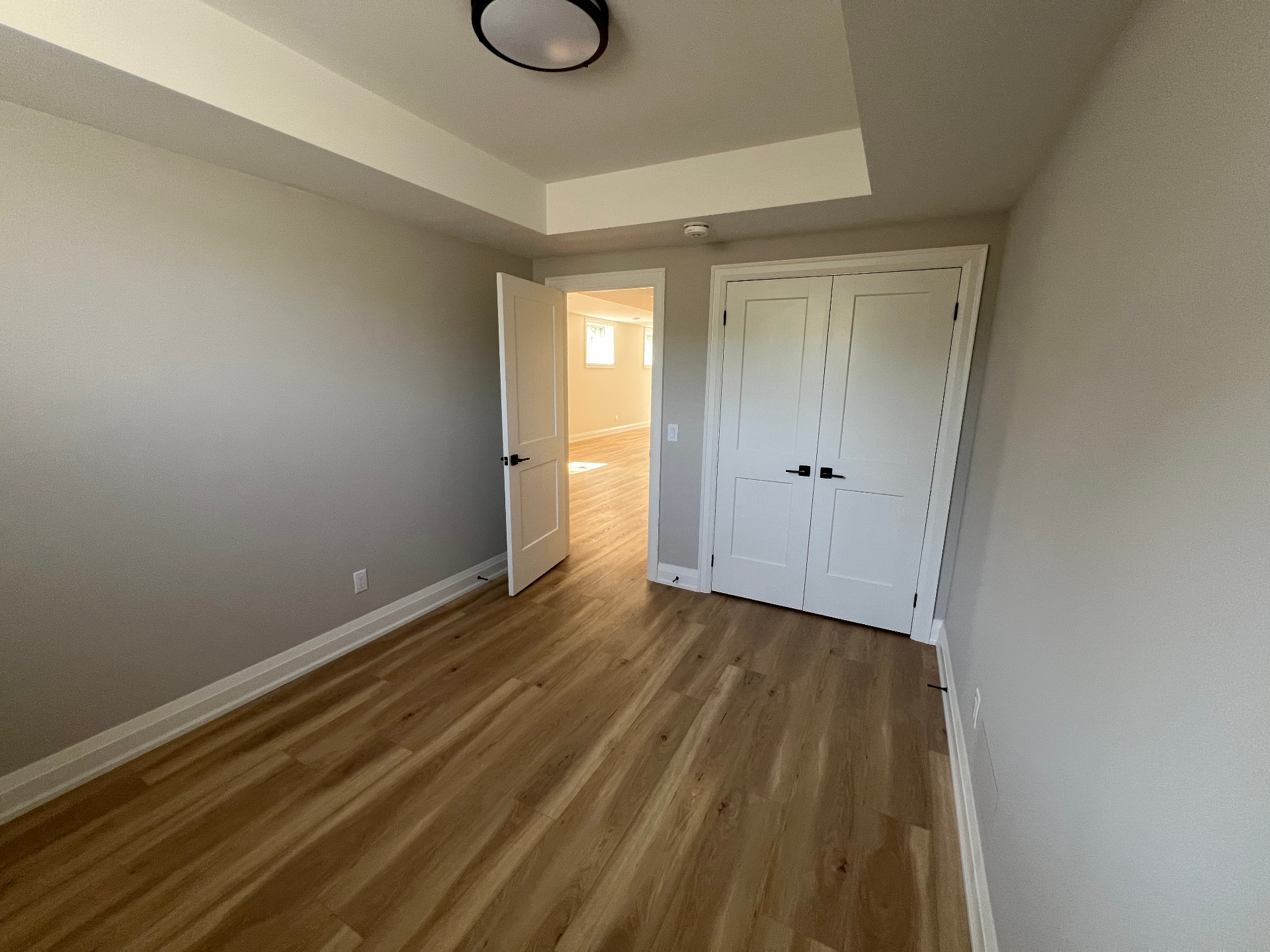 Finished basement bedroom with closet, doors and wood flooring in Niagara