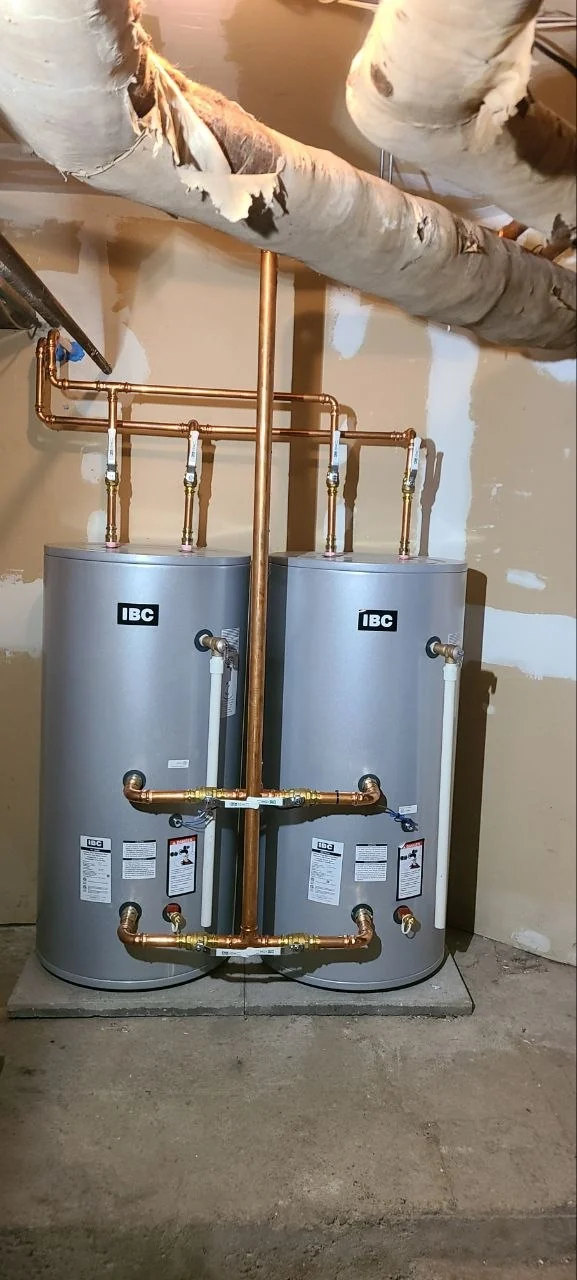 Two Rheem storage water heaters with connected copper pipework