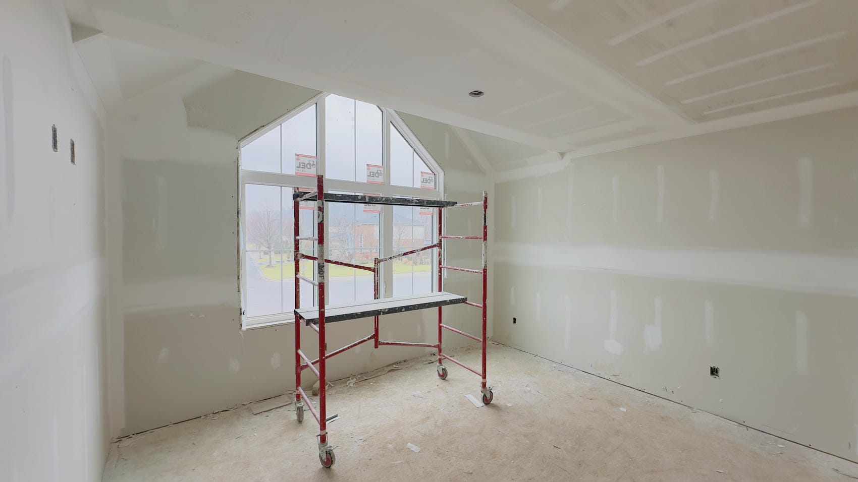 Drywall installation around gable window opening in Niagara renovation