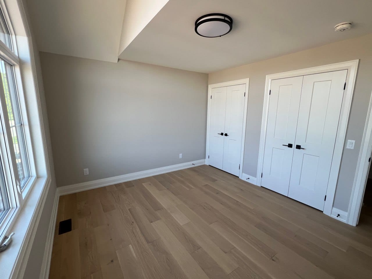 Grimsby interior renovation — bedroom with two double closets and hardwood flooring