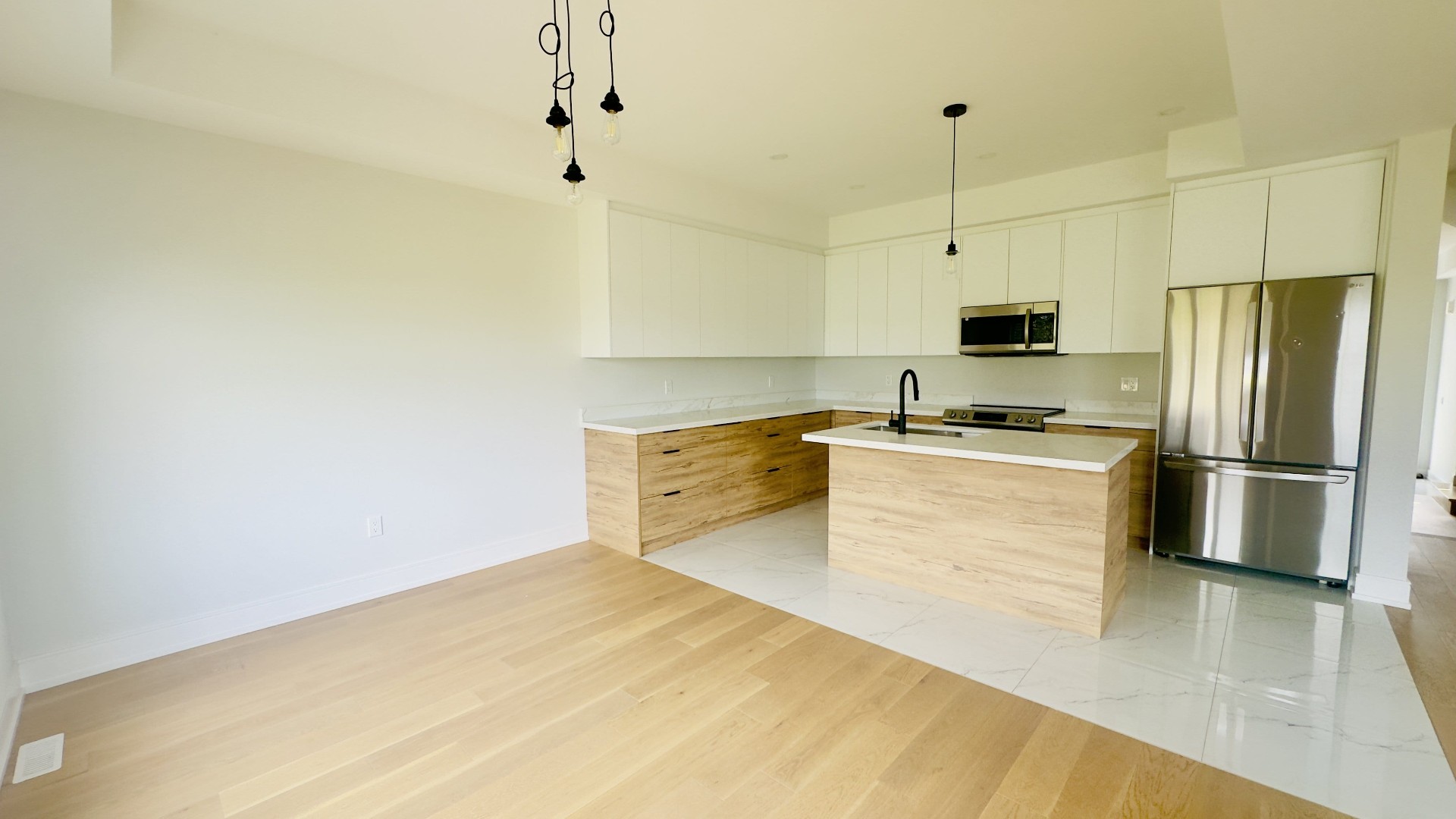 Modern kitchen renovation with wood cabinets, quartz island and stainless appliances in Niagara
