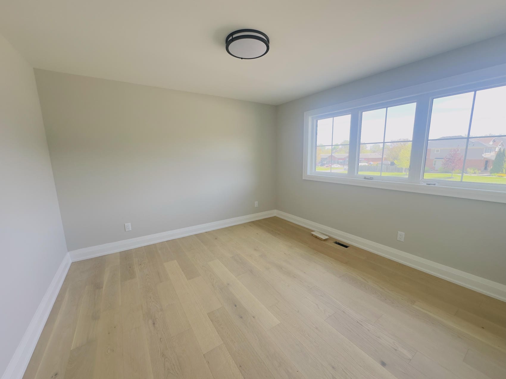 Bedroom with newly painted walls and white trim in Niagara home