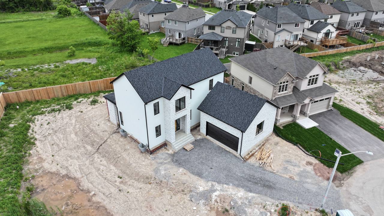 Aerial view of a modern residential stucco home in Niagara with stone accent garage and clean facade lines