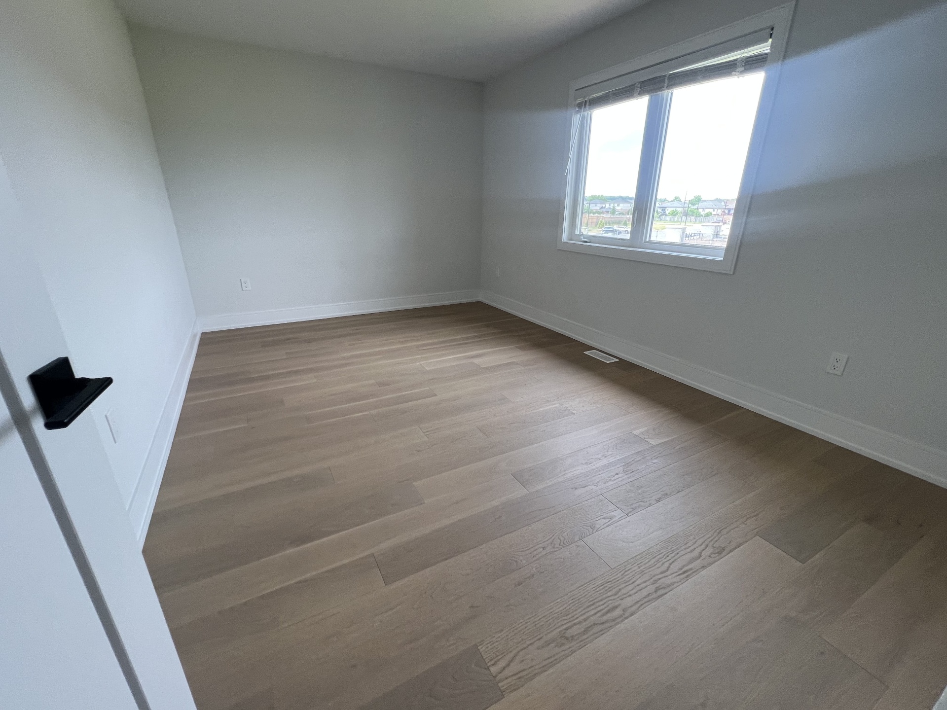 Niagara Falls interior renovation — finished bedroom with hardwood flooring and clean trim work