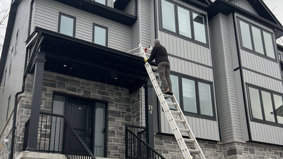 Black seamless aluminum eavestrough installation on a modern Niagara home