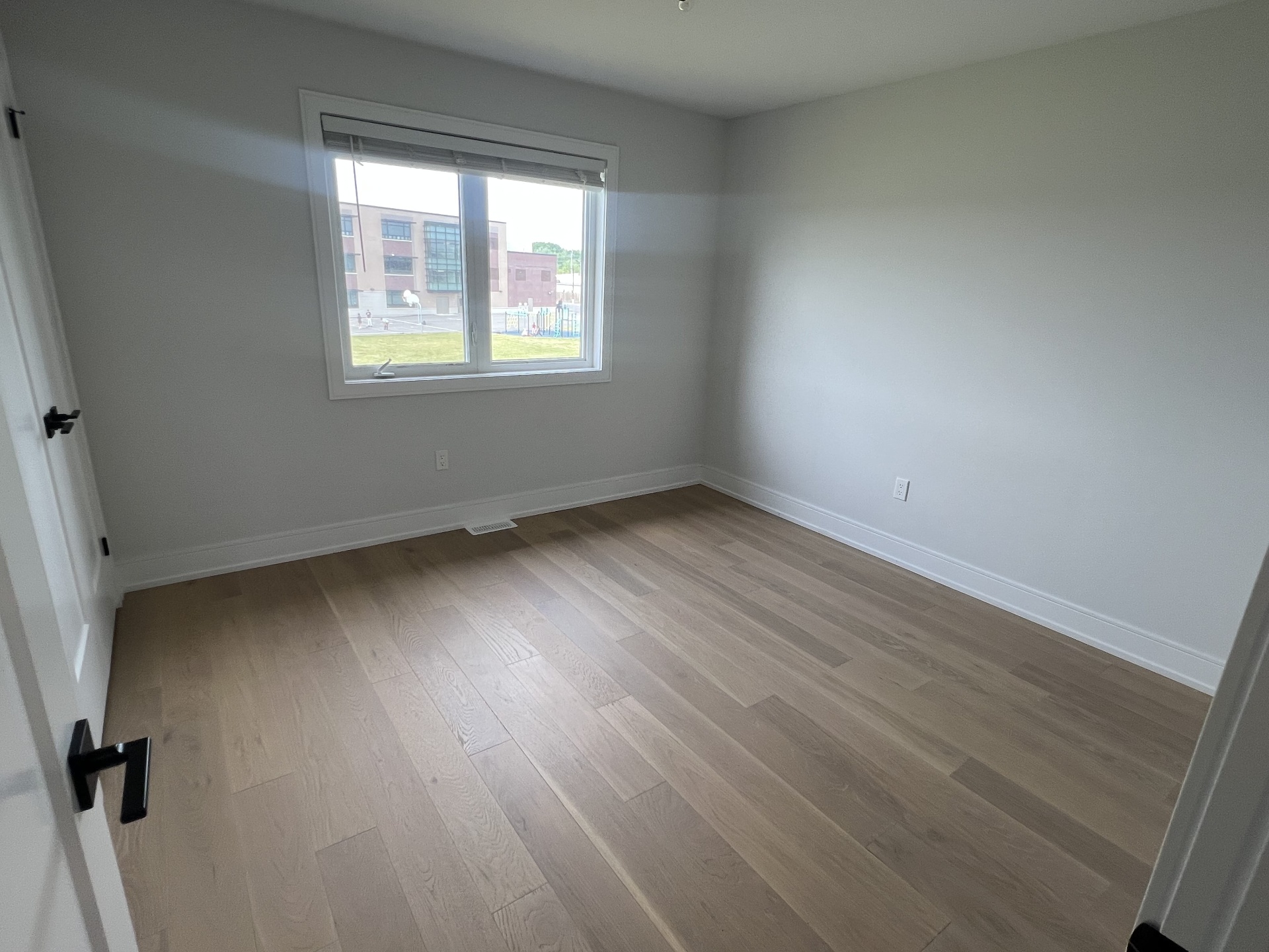Niagara Falls interior renovation — bedroom with large window, clean drywall, and modern baseboards
