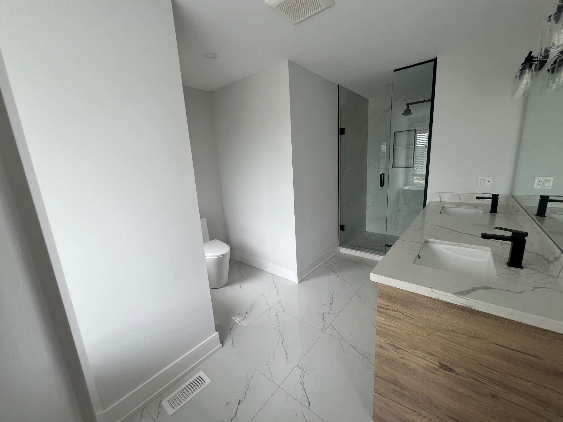 Bathroom renovation with marble tile floor and walk-in shower in Niagara