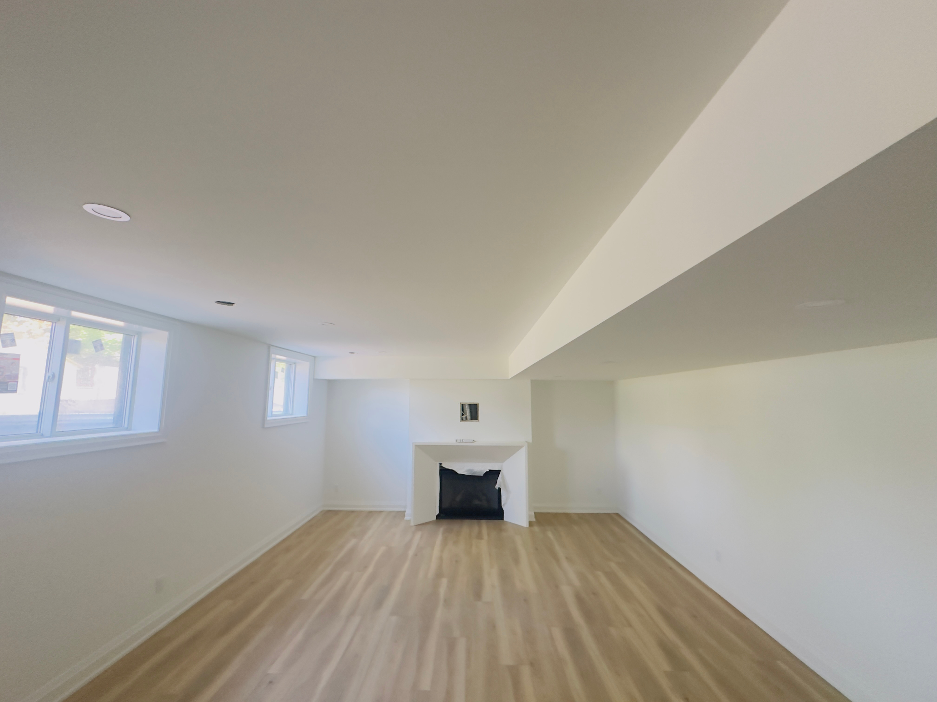 Finished basement living area with fireplace and hardwood flooring in Niagara