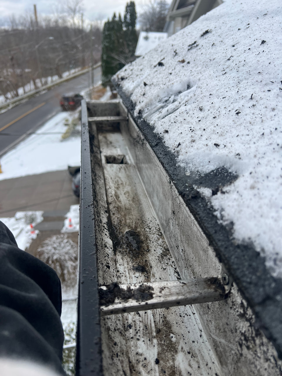 Dirty eavestrough interior showing debris buildup before cleaning in Niagara Region