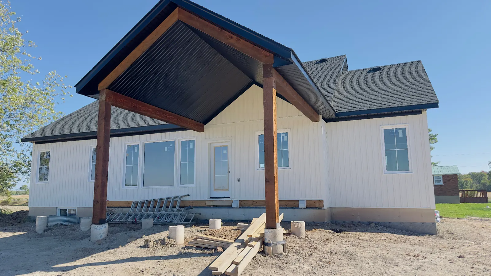 White board-and-batten home with black aluminum porch soffit
