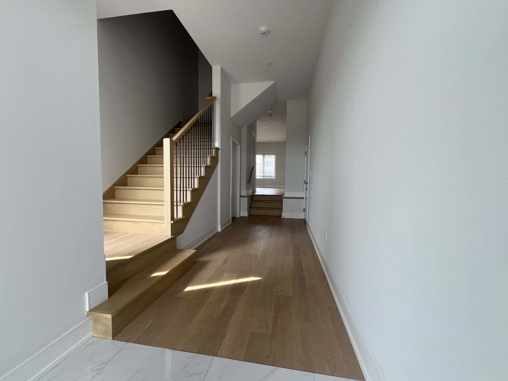 Niagara Falls interior renovation — two-storey entry hallway with maple staircase and dark accent wall