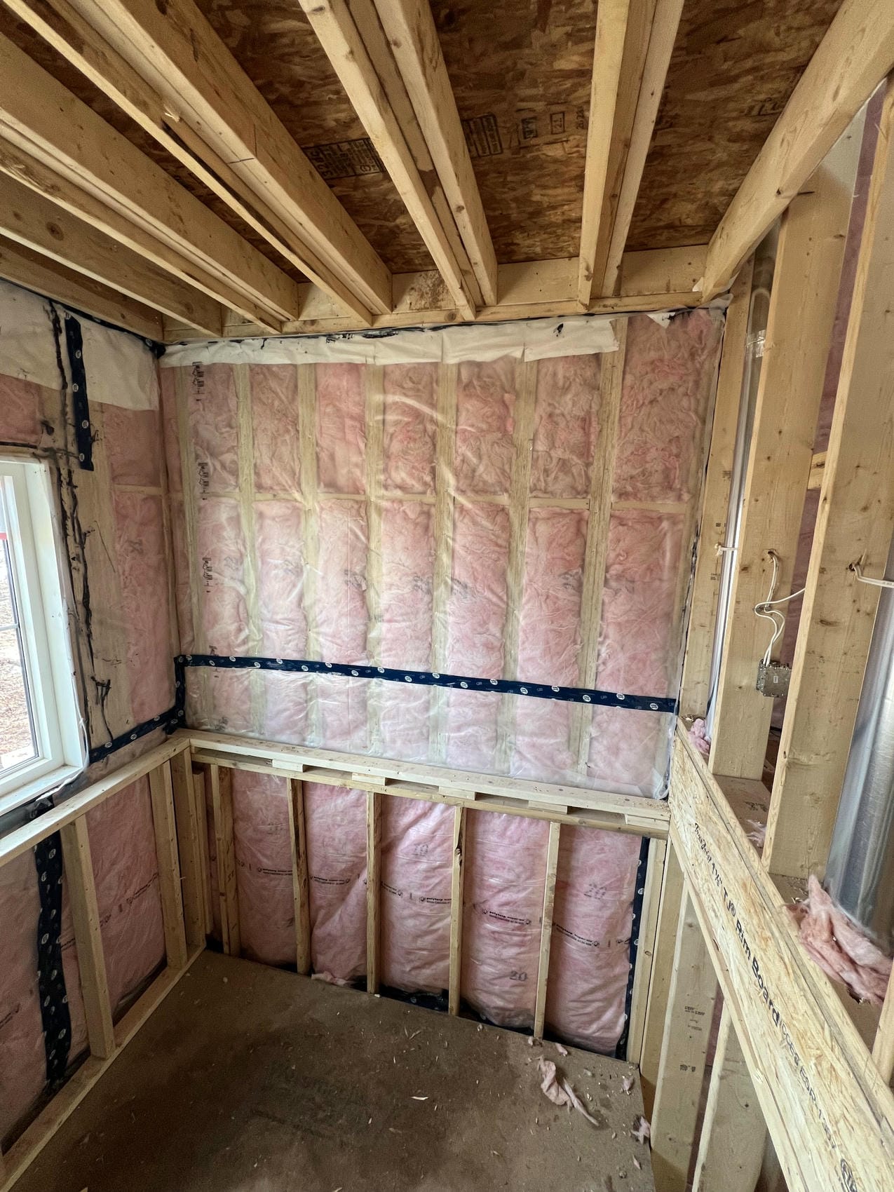 Pink fibreglass batt insulation in framed walls in Niagara