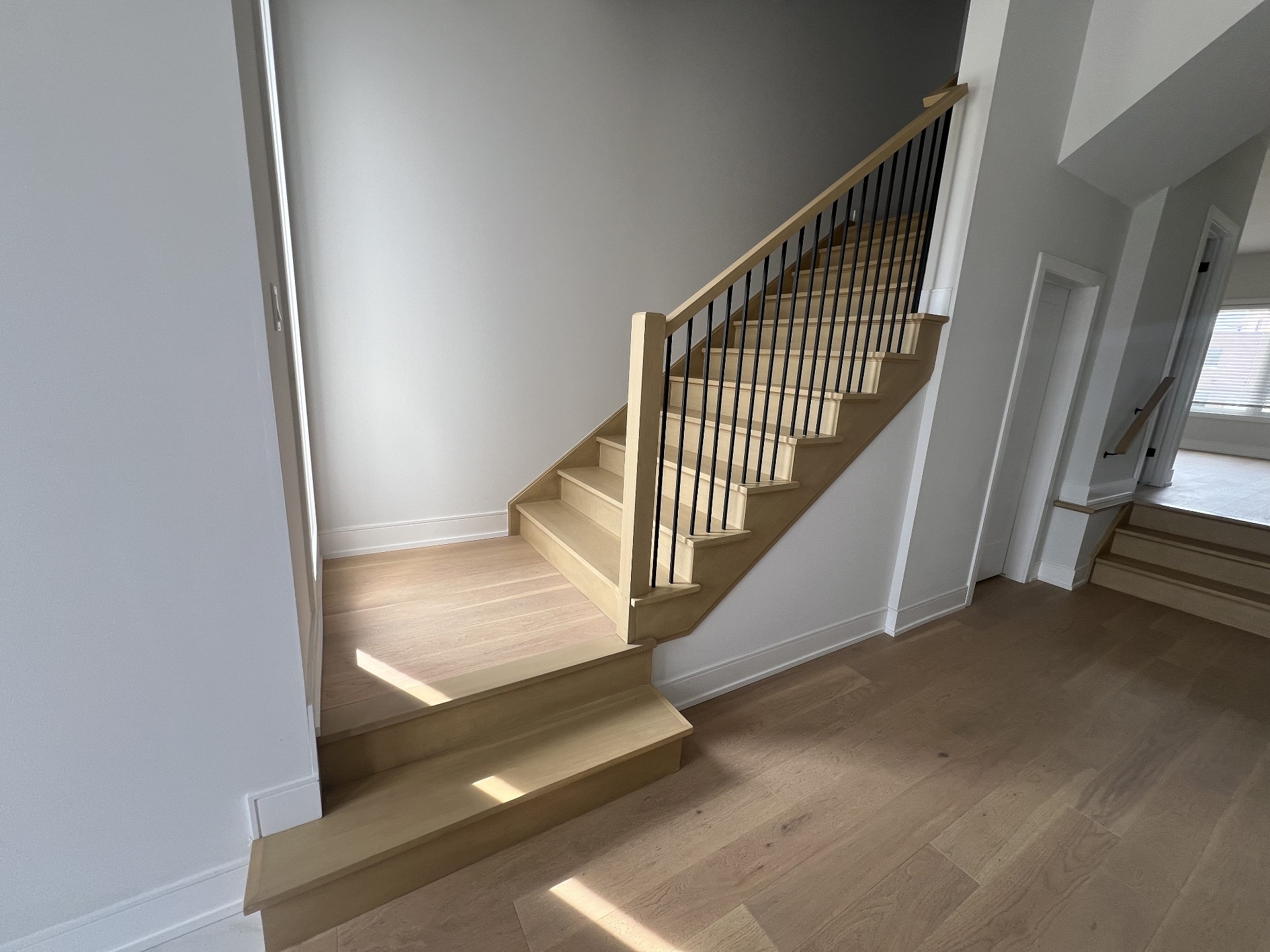 Niagara Falls interior renovation — finished maple staircase with black metal spindles
