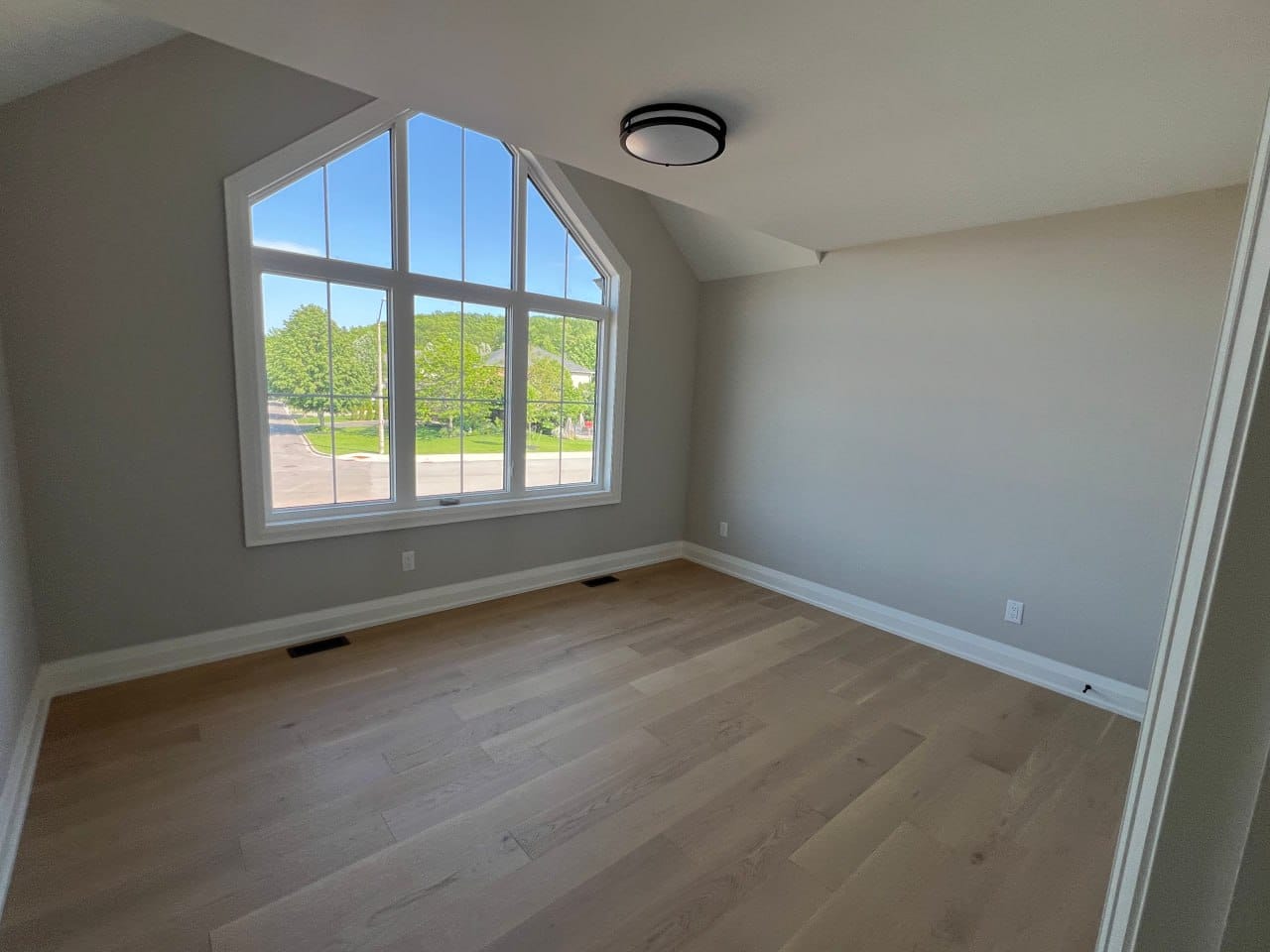 Grimsby interior renovation — bedroom with vaulted ceiling and large custom window