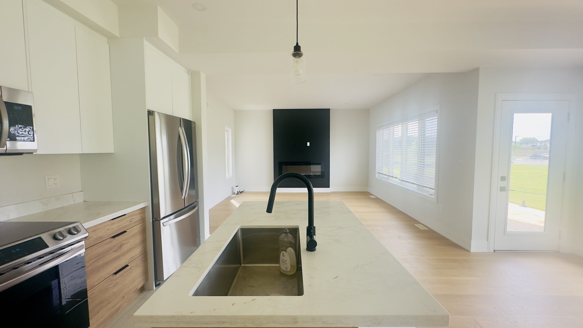 Kitchen renovation with quartz island, black faucet and stainless appliances in Niagara