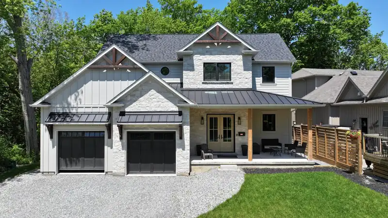 Exterior renovation project with stone, board & batten siding, and metal roof accents