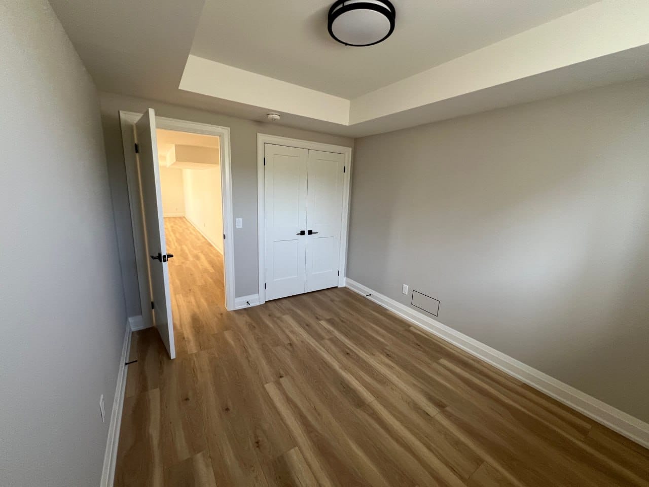 Grimsby interior renovation — finished bedroom with tray ceiling and double closet doors