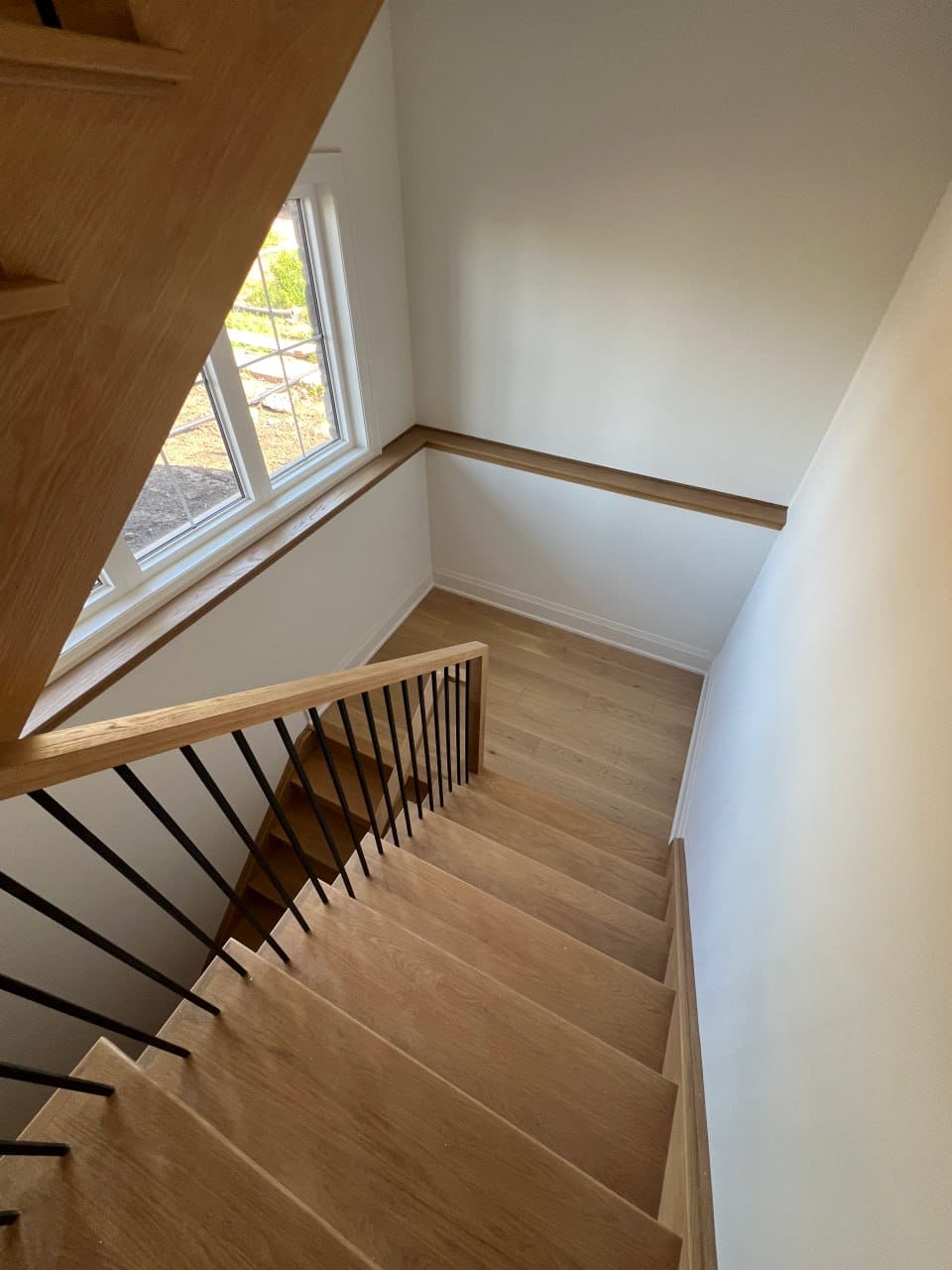 Grimsby interior renovation — finished oak staircase with black metal spindles