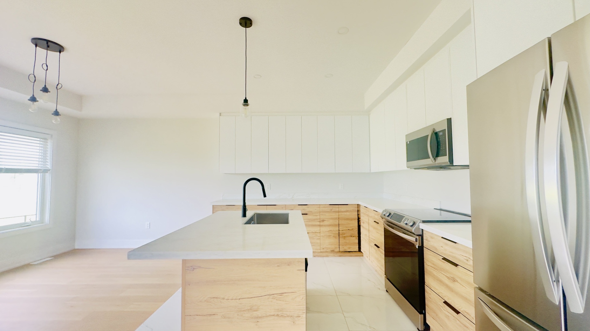 Modern kitchen renovation with two-tone cabinets and quartz island in Niagara